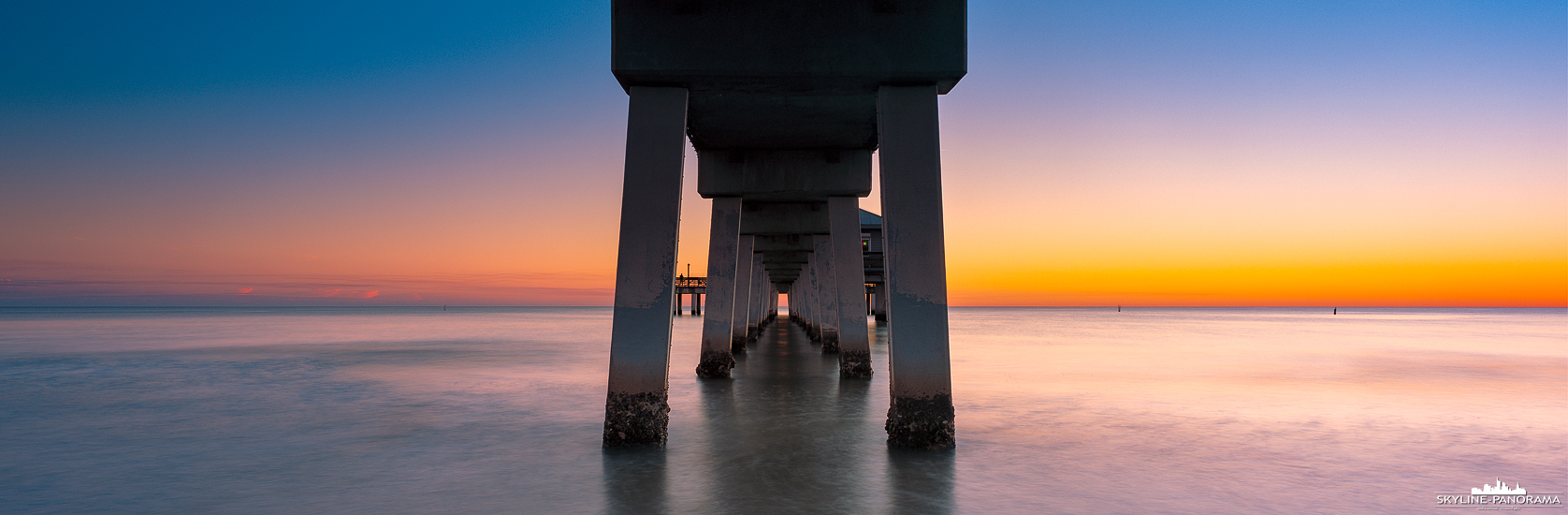 Panorama Florida - Zum Sonnenuntergang unter dem beliebten Pier von Fort Myers Beach, hier ist er noch vor dem katastrophalen Auswirkungen des Hurricane Ian zu sehen.